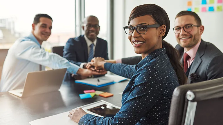 Business executives with hands in the center of table- 3DEXPERIENCE Works